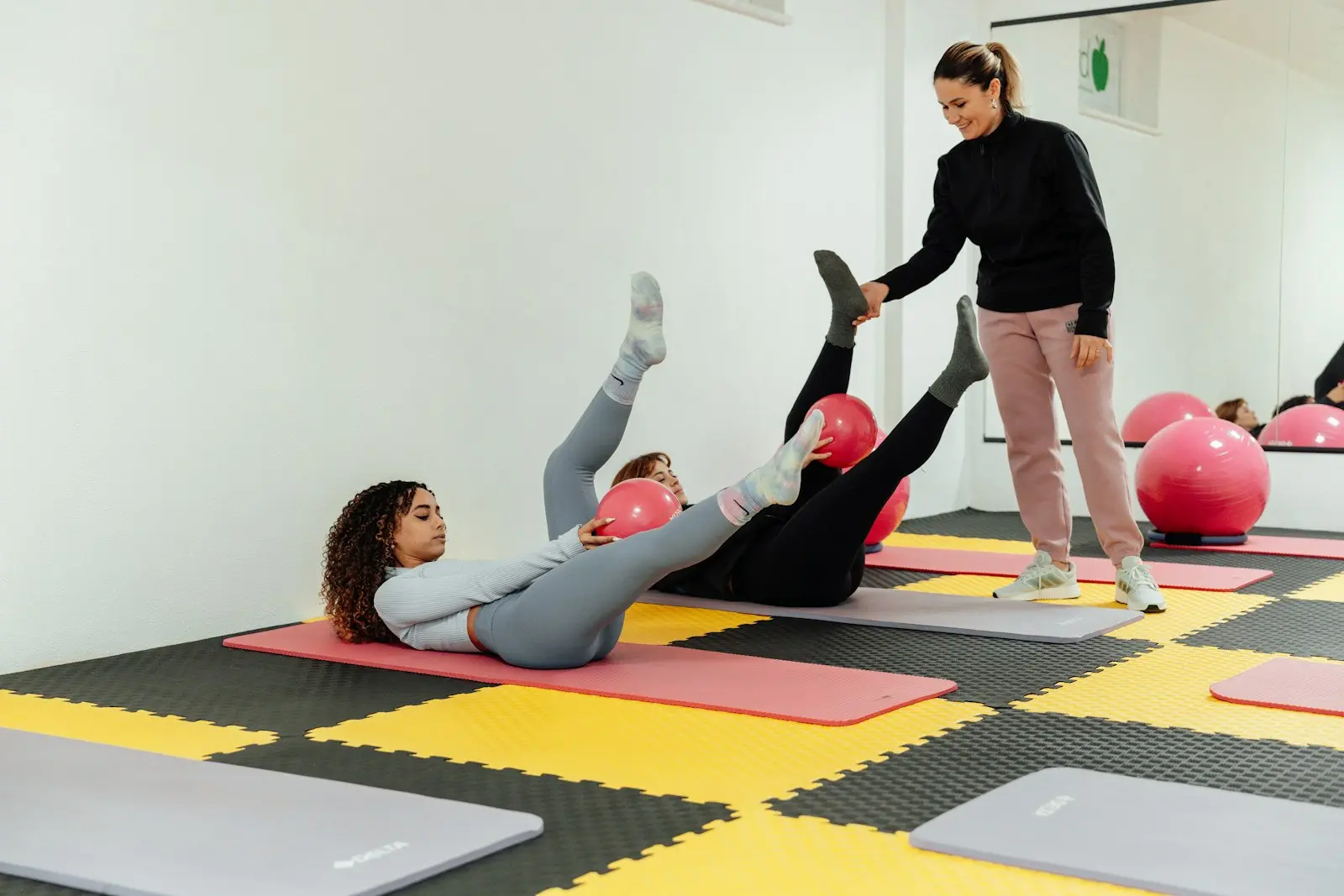 Instructrice qui guide une cliente pendant un exercice au sol