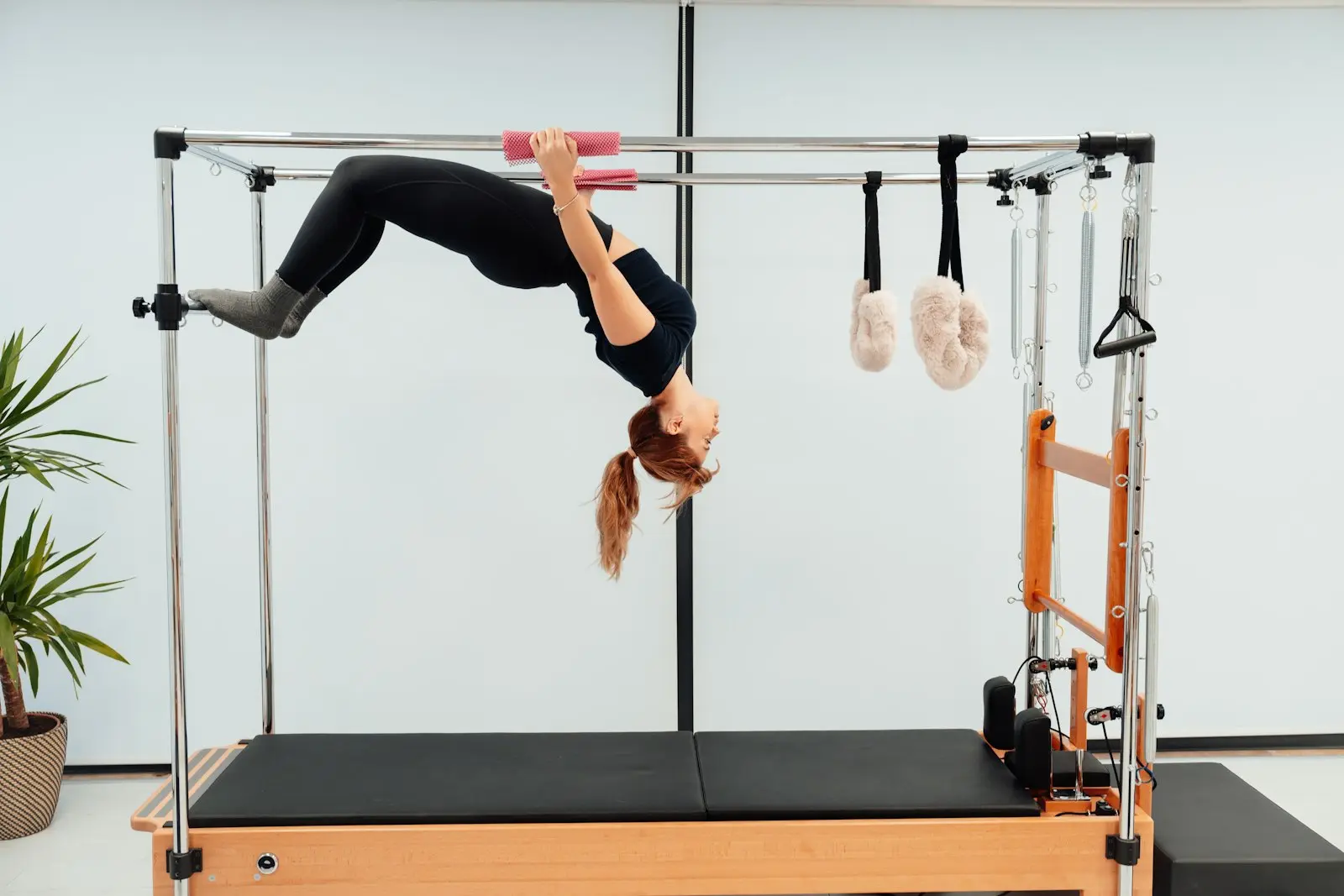 Femme en inversion suspendue sur un Cadillac de Pilates